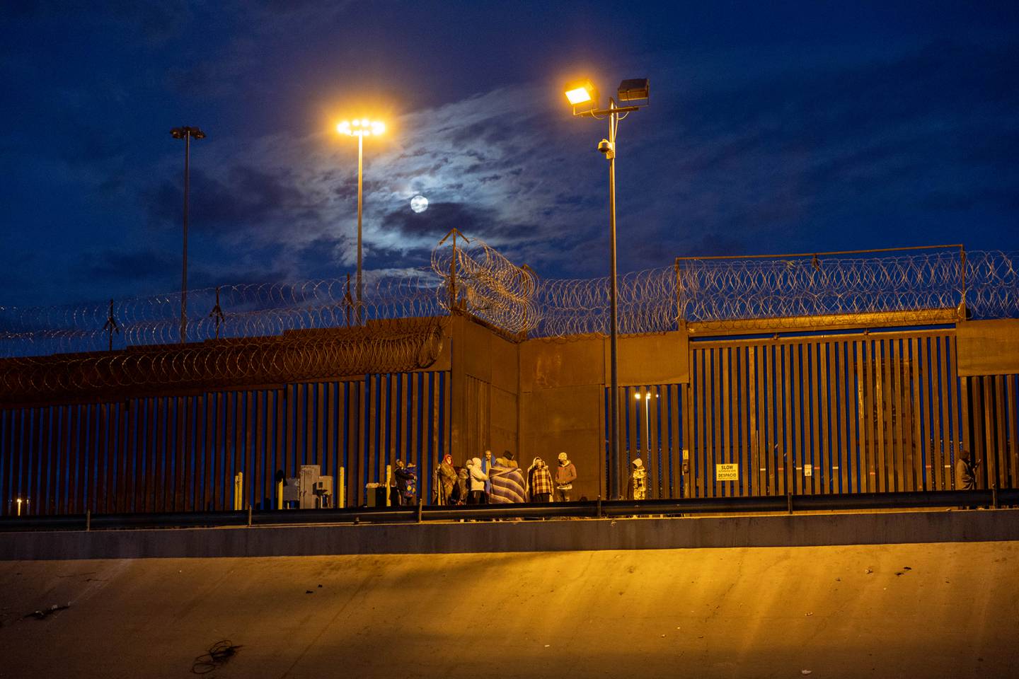 Immigrants wait overnight next to the U.S.-Mexico border fence to seek asylum in the United States on January 7, 2023, as viewed from Ciudad Juarez, Mexico.
