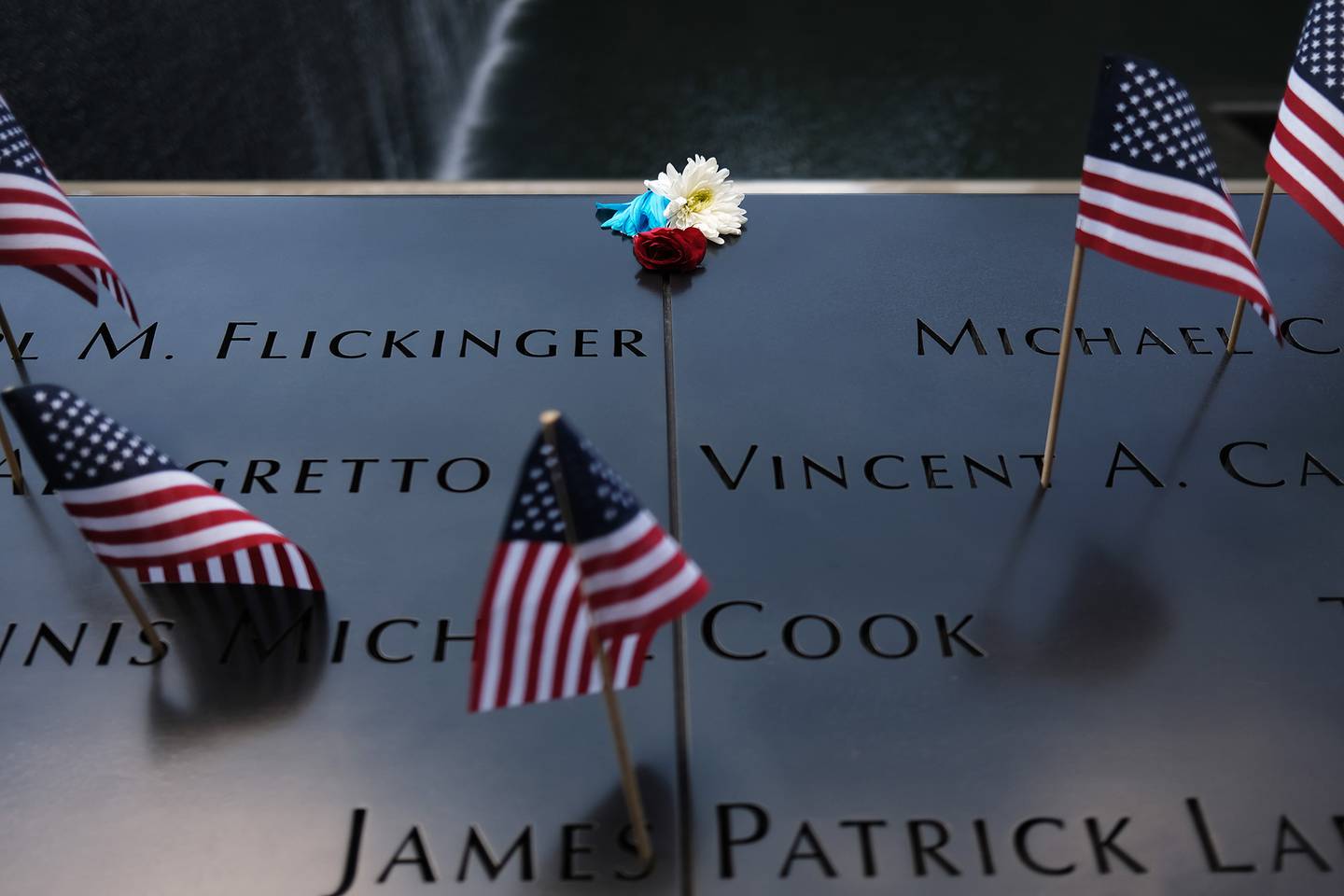 A flower is placed on a name at the 9/11 memorial plaza on the first day it reopened after closing for three months due to the coronavirus on on July 4, 2020, in New York City.