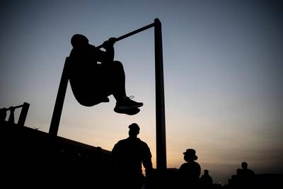 Army 1st Sgt. Christopher Williams, from U.S. Army Central Forward, based in Camp Arifjan, Kuwait, completes a leg tuck during an Army Combat Fitness Test, Jan. 25, 2021. (