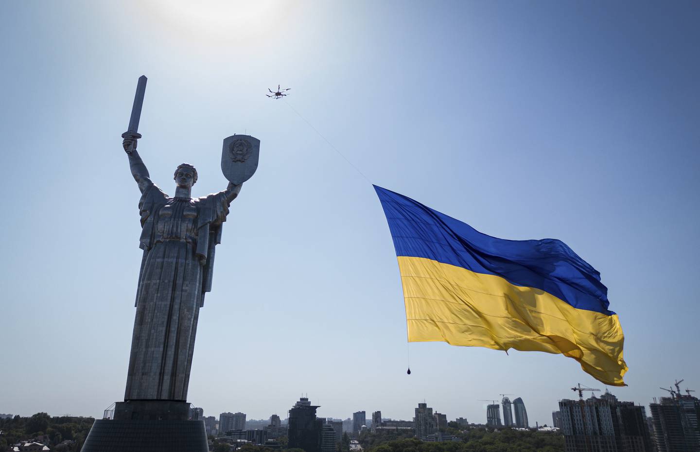 A drone carries a big national flag in front of Ukraine's the Motherland Monument in Kyiv, Ukraine, Wednesday, Aug. 24, 2022.