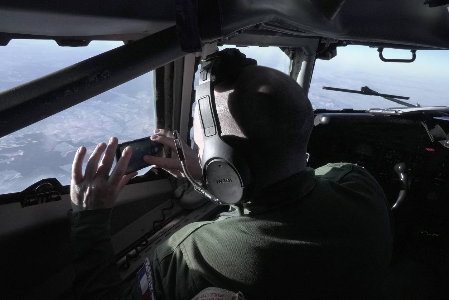 A crew member snaps a souvenir photo from the cockpit of a French military AWACS surveillance plane as it flies a 10-hour mission Tuesday, Jan. 9, 2024, to eastern Romania for the NATO military alliance.