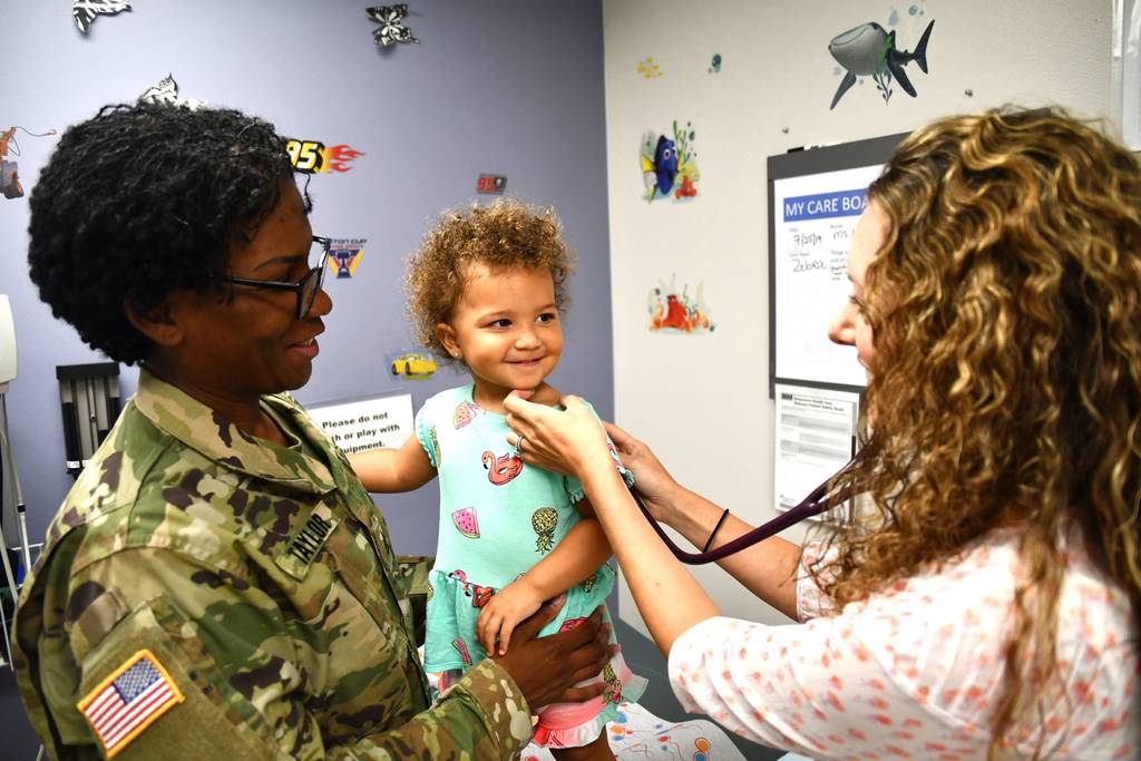 Nurse Practitioner Alison Gwinn listens with a stethoscope on Orianna Taylor at Kenner Army Health Clinic in Fort Lee, Virginia. (Lesley Atkinson).
