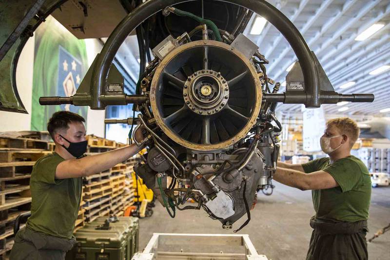 Marine Corps Sgt. William Easter, right, and Lance Cpl. Nathaniel Hinkle remove an engine from an Osprey aboard the amphibious assault ship USS Makin Island (LHD 8) on Jan. 19, 2021, in the Indian Ocean.