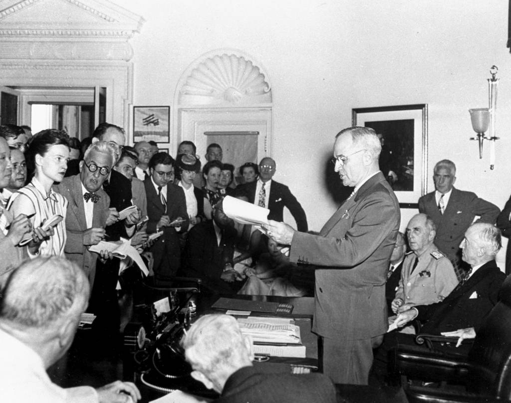 In this Aug. 14, 1945, file photo, President Harry S. Truman reads to newsmen his announcement of the Japanese surrender, officially signaling the war's end.