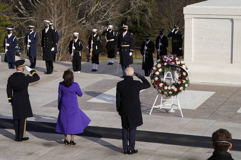 President Joe Biden, center, Vice President Kamala Harris, and Maj. Gen. Omar J. Jones salute at the Tomb of the Unknown Soldier at the Arlington National Cemetery on Jan. 20, 2021, in Arlington, Va.