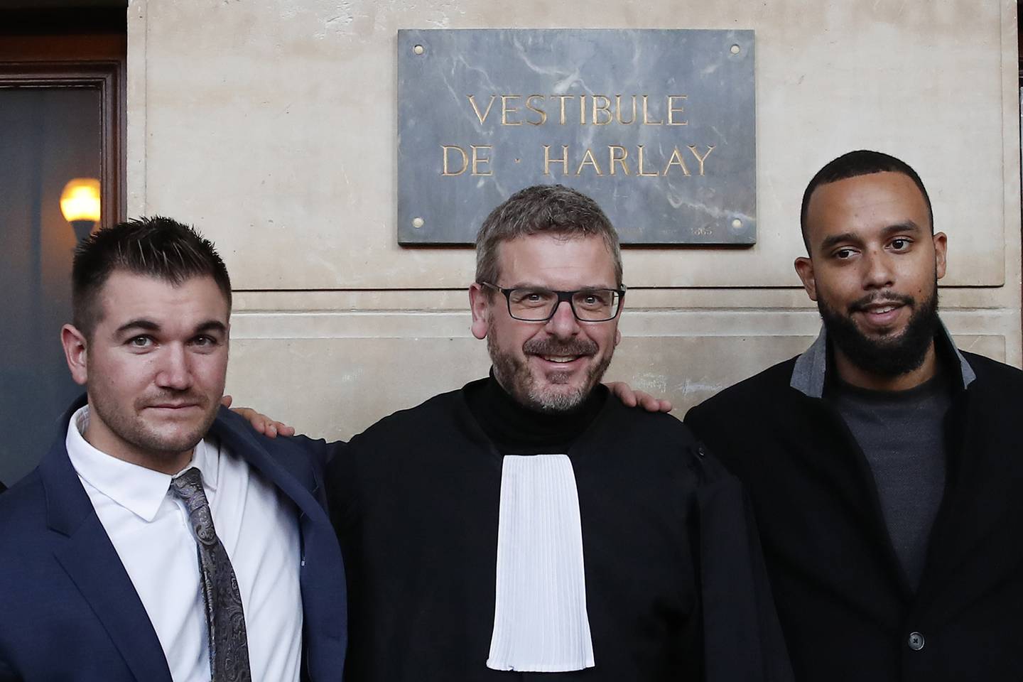 Alek Skarlatos, left, Anthony Sadler, right, and their lawyer Thibault de Montbrial, pose for photographers at the end of their hearing during the Thalys attack trial at the Paris courthouse, Friday, Nov. 20, 2020.