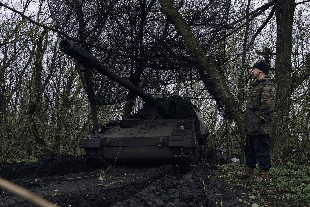 A Ukrainian soldier stands near a German self-propelled Panzerhaubitze 2000 artillery at his position on the frontline in Bakhmut, Donetsk region, Ukraine, Thursday, April 13, 2023.