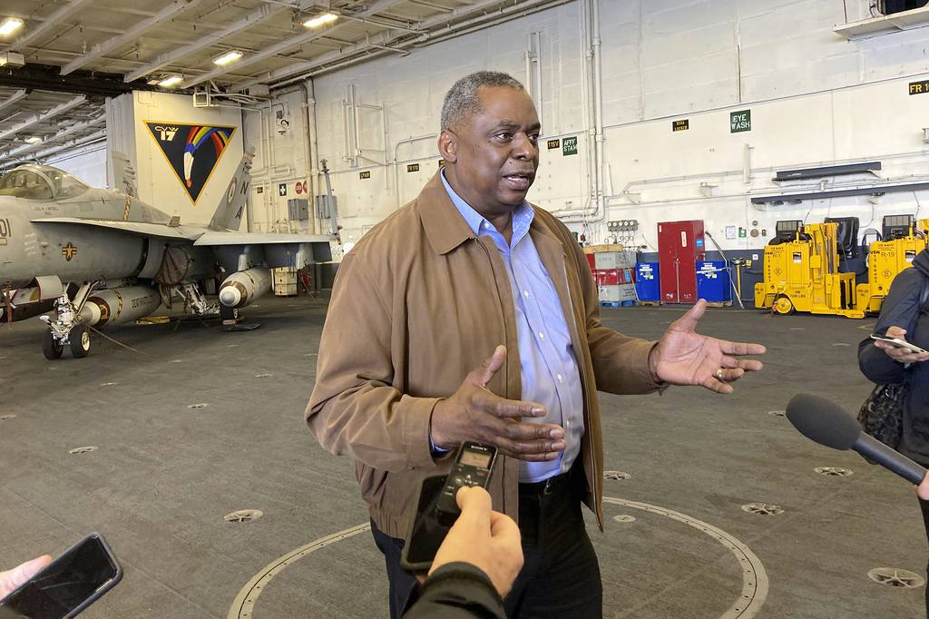 Defense Secretary Lloyd Austin speaks to reporters after arriving on the aircraft carrier USS Nimitz, Thursday, Feb. 25, 2021, at sea.
