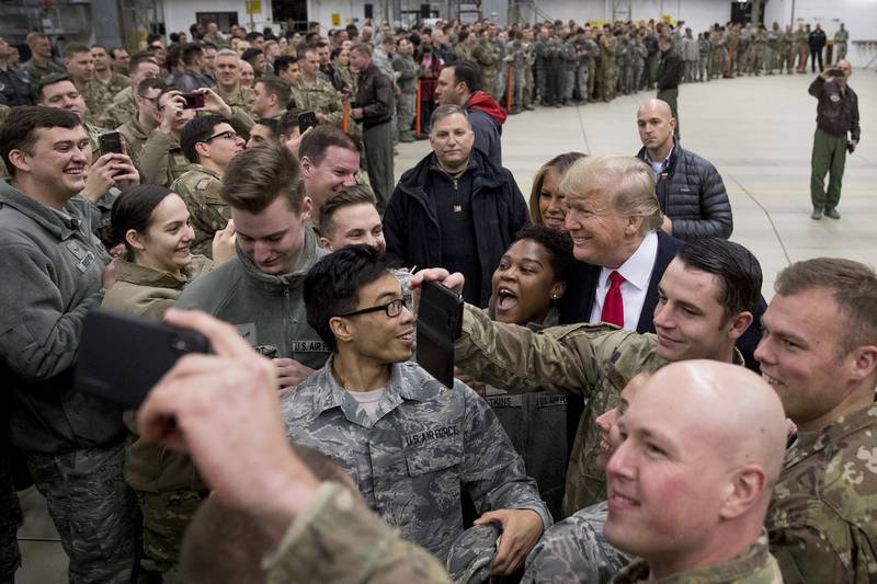 In this Dec. 27, 2018, file photo, President Donald Trump, center right, and first lady Melania Trump, center left, greet members of the military at Ramstein Air Base, Germany.