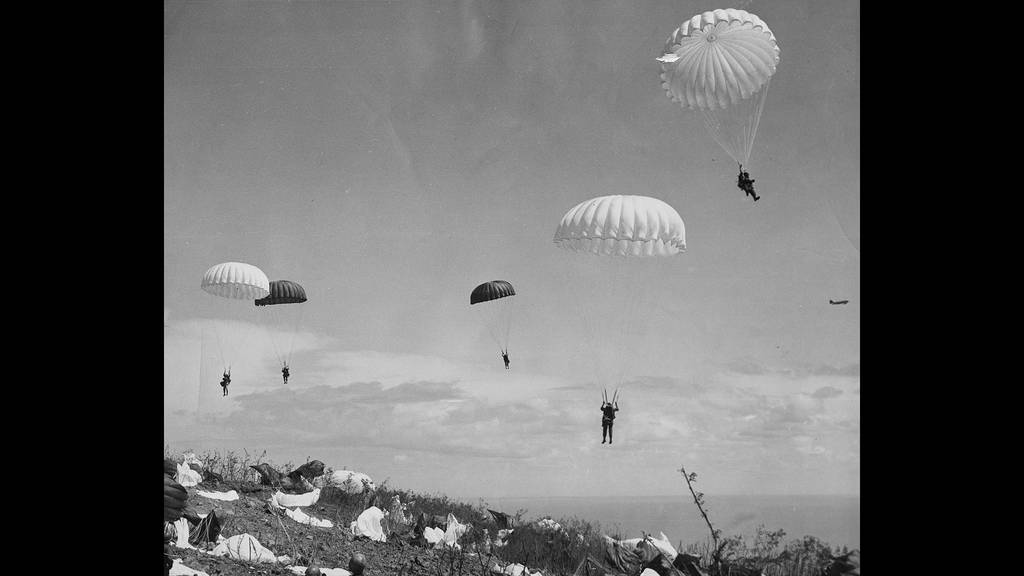 In this photo provided by the U.S. Army Signal Corps, paratroopers of the 503rd Paratroop Regiment float to the earth on the top of Corregidor as they began the American assault on "The Rock" guarding the entrance to Manila Bay, Feb. 24, 1945.
