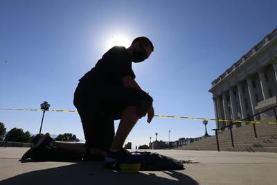 Shane Brooks, a Marine Corps veteran, kneels for nine hours outside the Utah Capitol to call attention to racial injustice, police brutality and mental health, Thursday, Aug. 6, 2020, in Salt Lake City.
