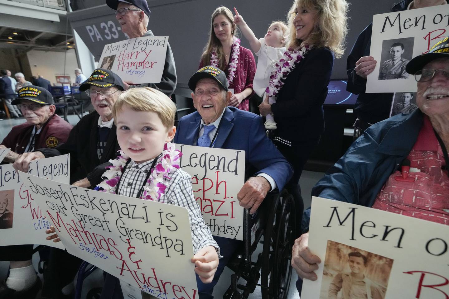 World War II veteran Joseph Eskenazi, who at 104 years and 11 months old is the oldest living veteran to survive the attack on Pearl Harbor, sits with fellow veterans, his great grandchildren Mathias, 4, Audrey, 1, and their grandmother Belinda Mastrangelo, at an event celebrating his upcoming 105th birthday at the National World War II Museum in New Orleans, Wednesday, Jan. 11, 2023.