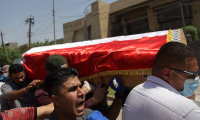 Mourners carry the flag-draped coffin of Hisham al-Hashimi during his funeral, in the Zeyouneh area of Baghdad on July, 7, 2020.