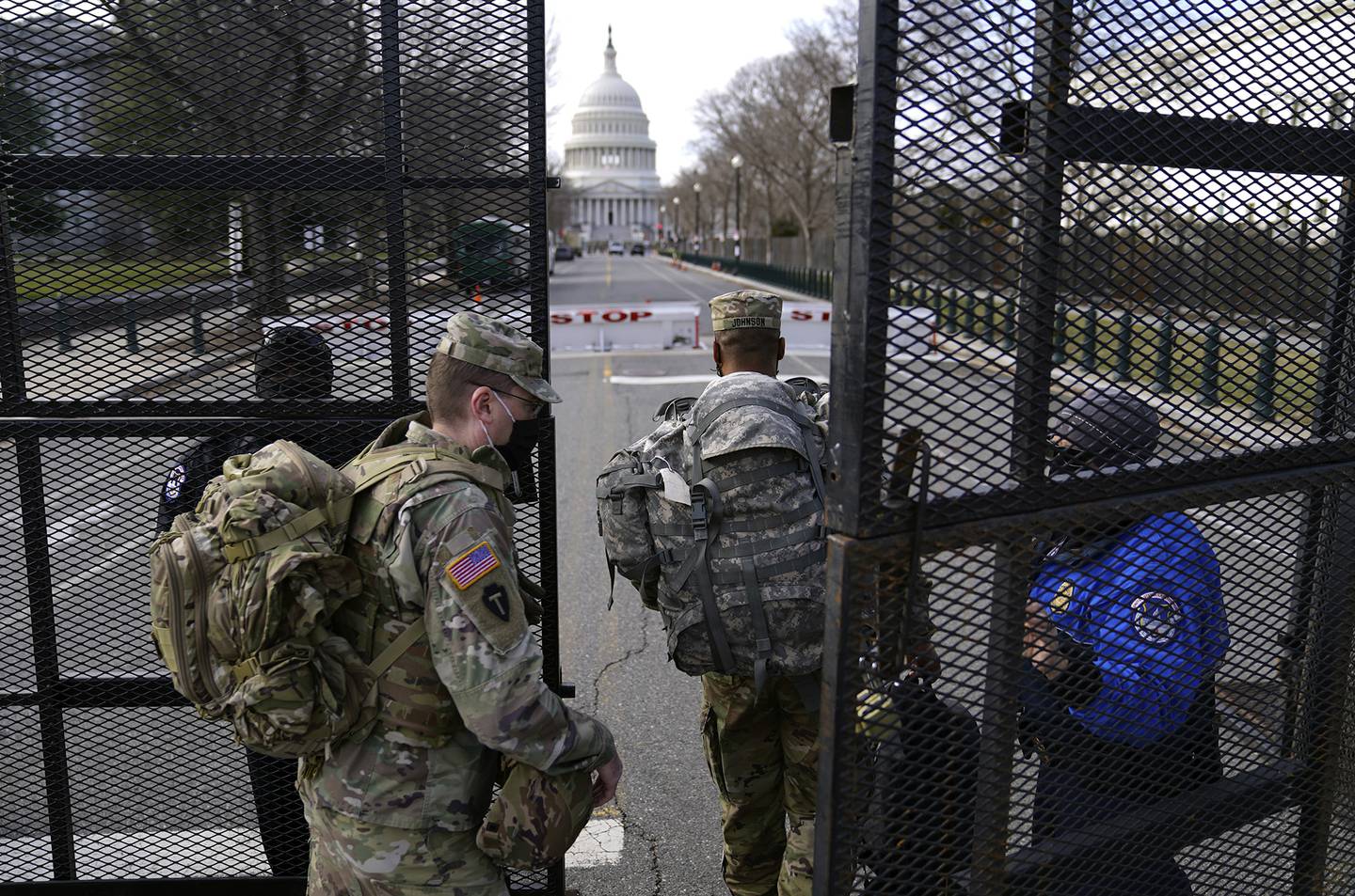 With the U.S. Capitol in the background, troops are let through a security gate on Saturday, Jan. 16, 2021, in Washington as security is increased ahead of the inauguration of President-elect Joe Biden and Vice President-elect Kamala Harris.
