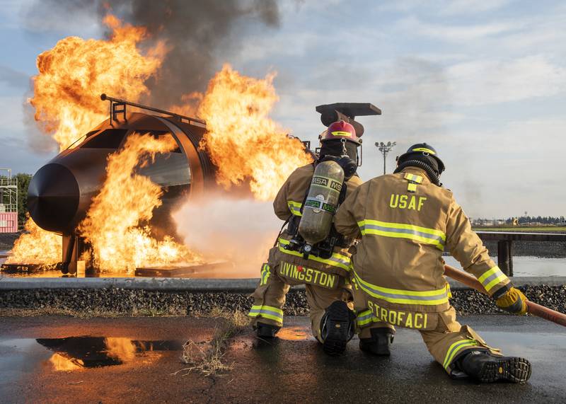 Staff Sgt. Dillon Livingston, left, and Senior Airman Jade Strofaci, 374th Civil Engineer Squadron firefighters, participate in a live-fire training scenario, Oct. 27, 2020, at Yokota Air Base, Japan.