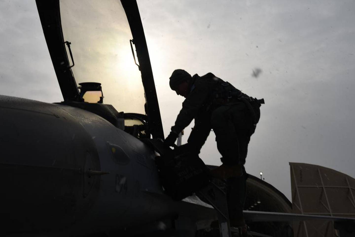 Lt. Gen. Scott Pleus climbs into an F-16 fighter jet