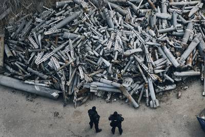 Police officers look at collected fragments of the Russian rockets, including cluster rounds, that hit Kharkiv, in Kharkiv, Ukraine, on Dec. 3, 2022.
