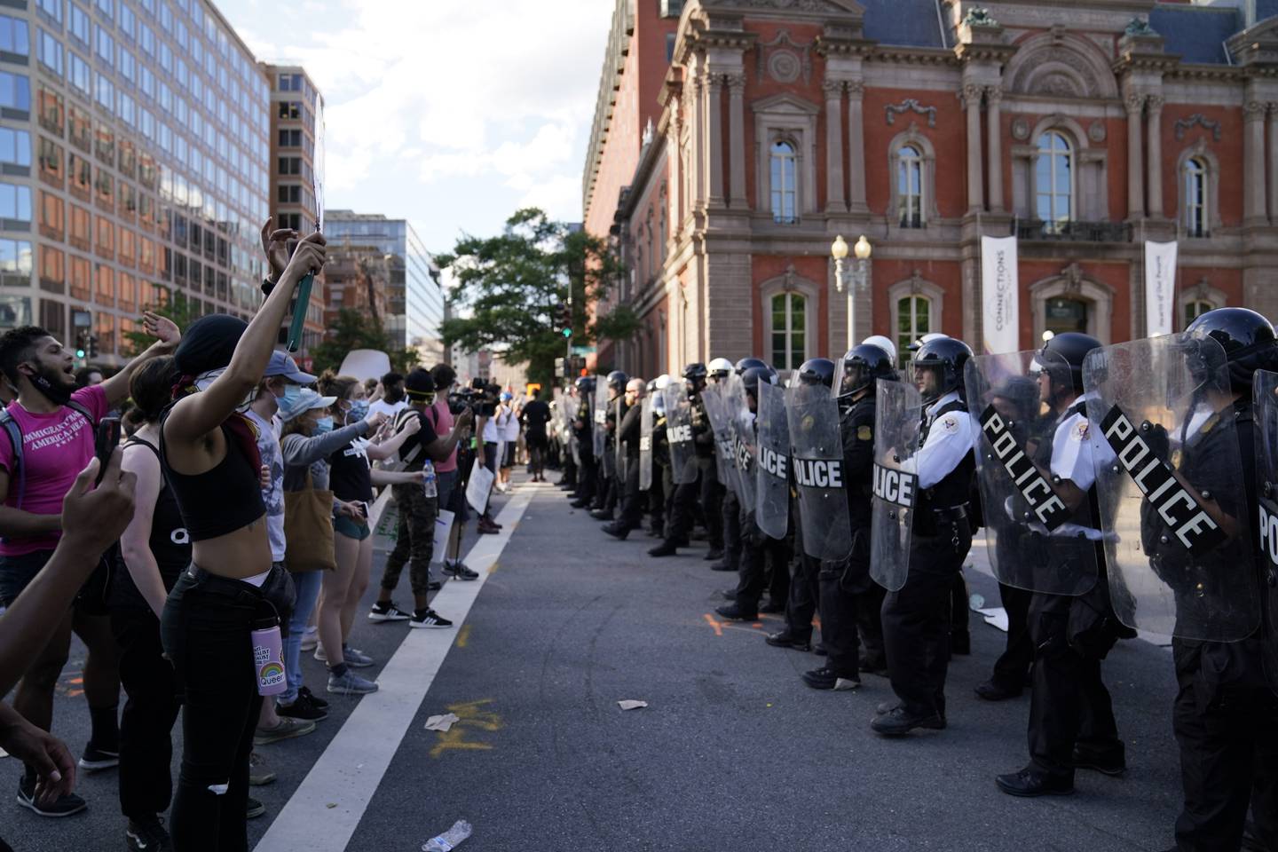 Demonstrators vent to police in riot gear as they protest the death of George Floyd, Saturday, May 30, 2020, near the White House in Washington. Floyd died after being restrained by Minneapolis police officers.
