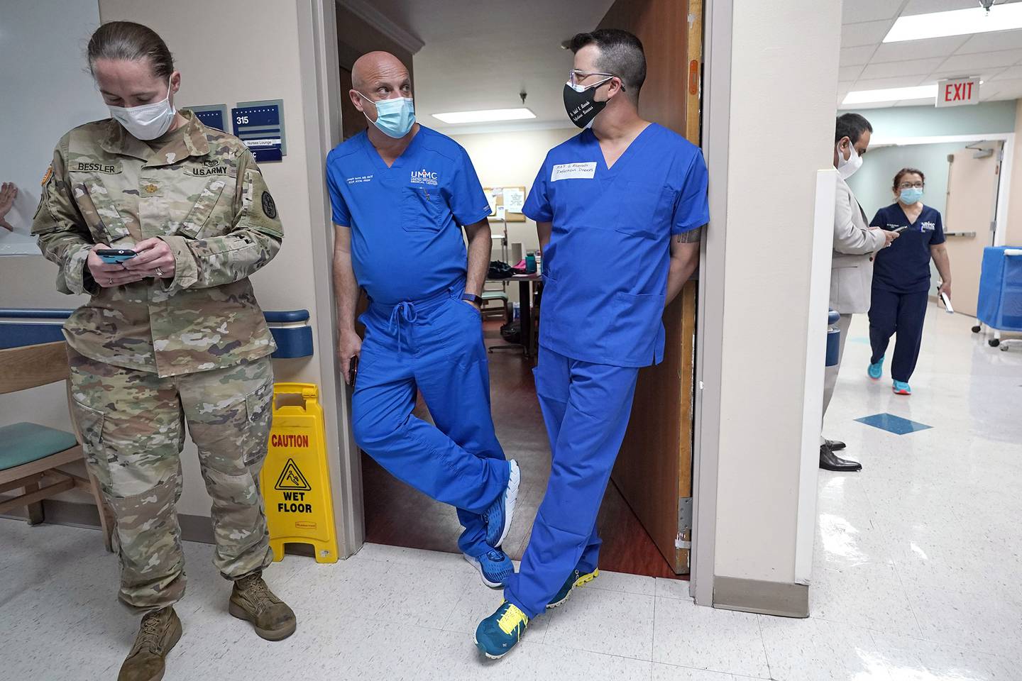 United Memorial Medical Center's Dr. Joesph Varon, center, talks with Infectious Disease Physician Army Maj. Gadiel Alvarado, right, as Maj. Katy Bessler, left, checks her phone as members of the Urban Augmentation Medical Task Force work to setup a wing in the hospital Thursday, July 16, 2020, in Houston.