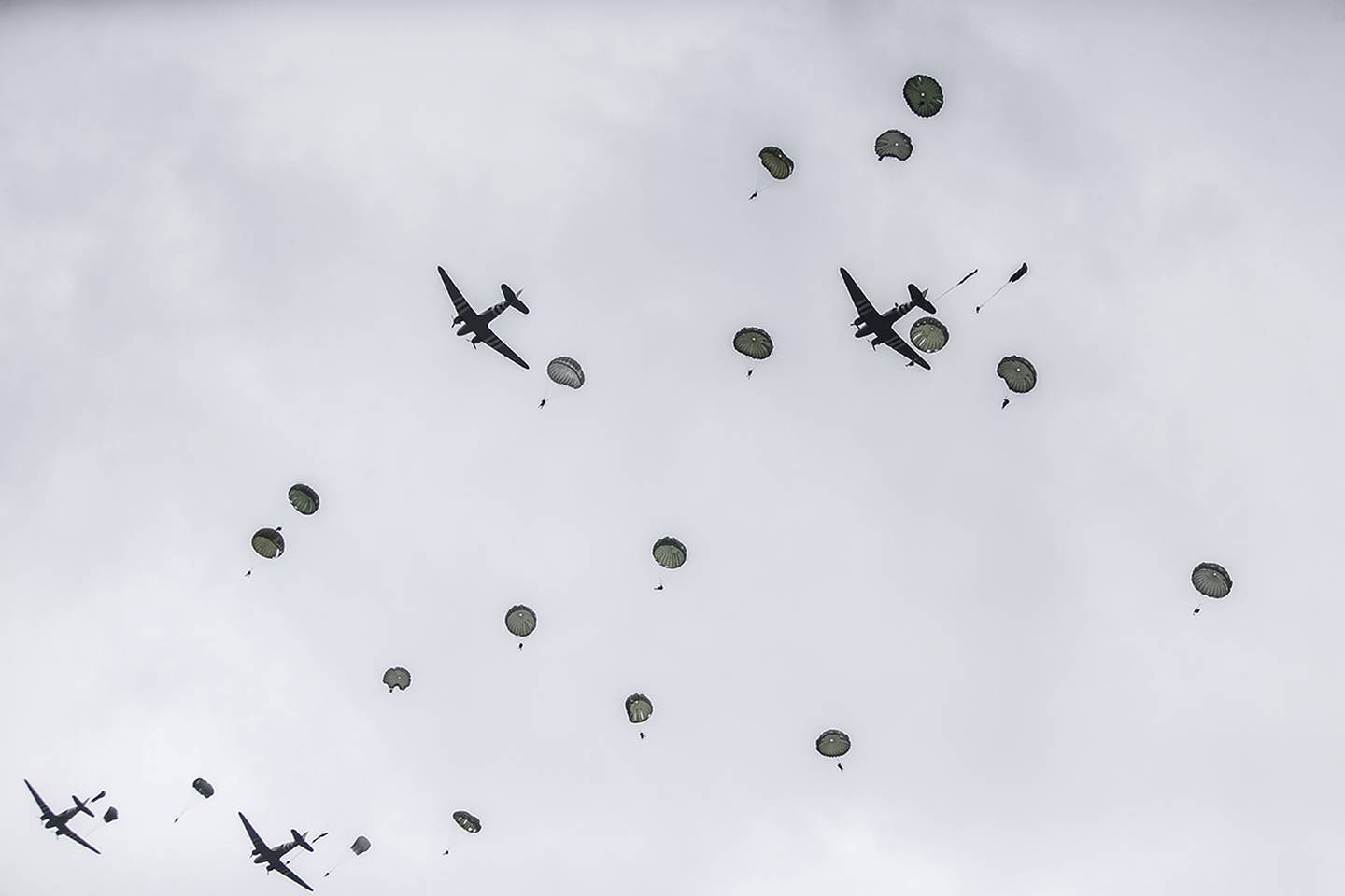 Parachutists jump from C-47 transport planes in Carentan, Normandy, France.
