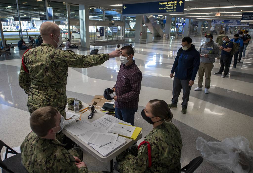 Staff assigned to Recruit Training Command process recruits on April 21, 2020, as part of a preliminary health screening at Chicago O’Hare International Airport.
