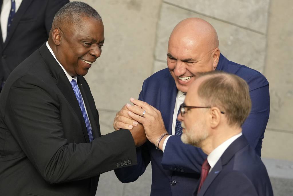 United States Secretary of Defense Lloyd Austin, left, shakes hands with Italy's Defense Minister Guido Crosetto during a group photo during a meeting of the North Atlantic Council in defense ministers format at NATO headquarters in Brussels, Thursday, Oct. 12, 2023.