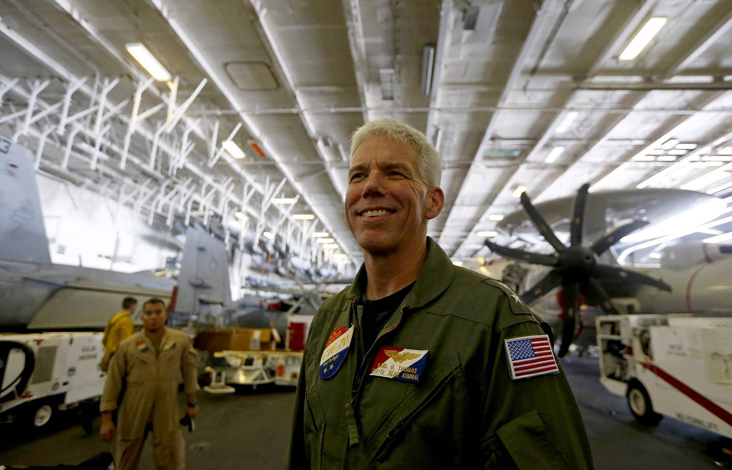 Rear Adm. Karl Thomas, Task Force 70/commander, Carrier Strike Group 5, poses before an E-2 Hawkeye plane following a media interview aboard the U.S. aircraft carrier USS Ronald Reagan off South China Sea on Aug. 6, 2019.