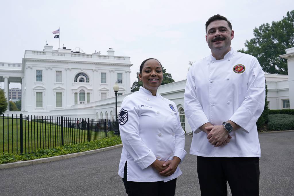 Air Force Master Sgt. and chef Opal Poullard, left, and Marine Corps Gunnery Sgt. and chef Dustin Lewis, right, pose for a photo at the White House in Washington, Friday, June 30, 2023.