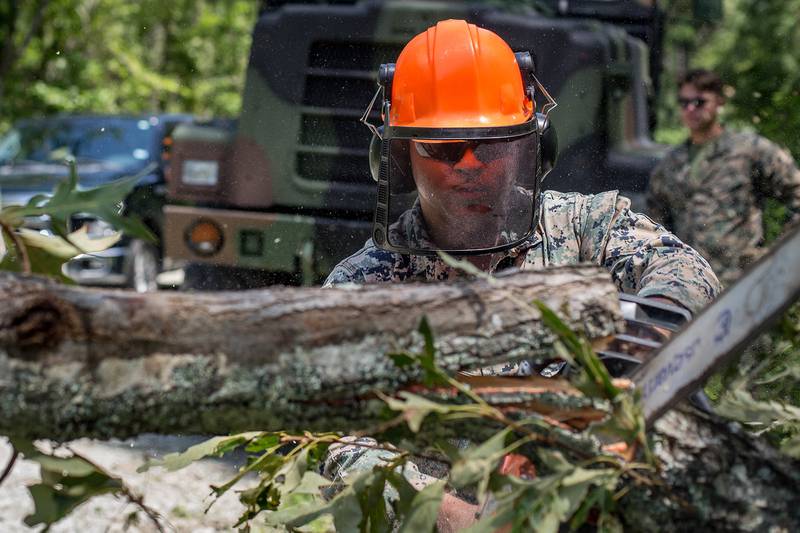 Cpl. William Butler uses a chainsaw to clear debris on a training area road at Marine Corps Air Station New River, N.C., Aug. 4, 2020, after Hurricane Isaias in order to resume normal operations.