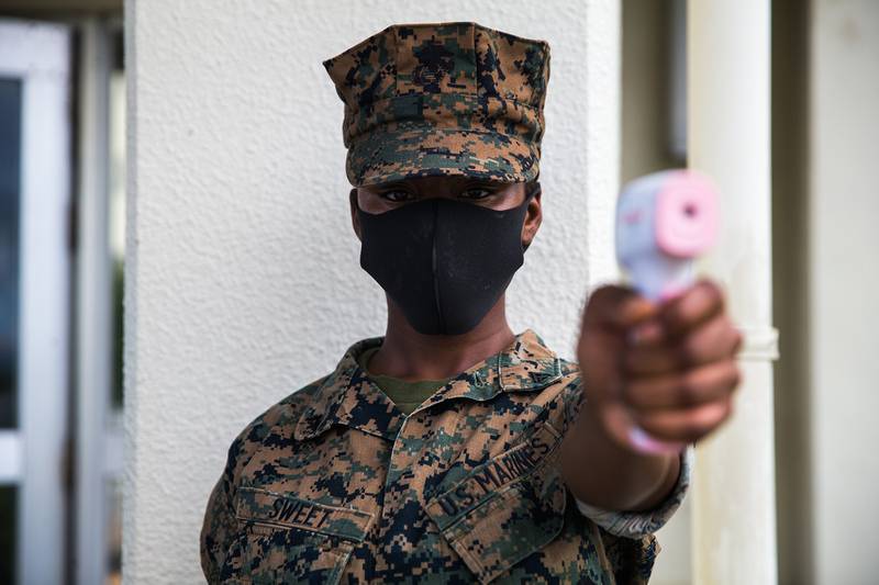U.S. Marine Corps Lance Cpl. Denya Sweet conducts temperature checks in front of the dining facility on Camp Courtney, Okinawa, Japan, July 13, 2020.