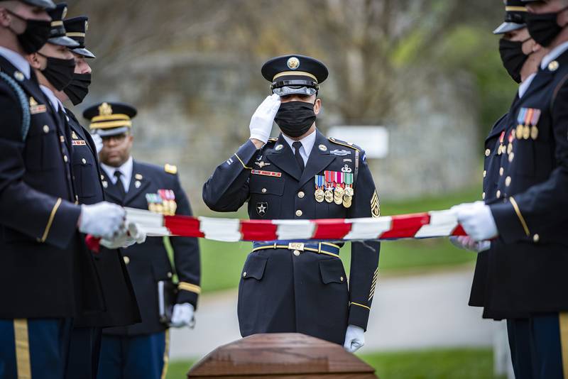 A soldier assigned to The Old Guard renders honors shortly after the chaplain provided his blessing April 14, 2020, during the funeral for retired Army Command Sgt. Maj. Robert M. Belch in Arlington National Cemetery, Arlington, Va.