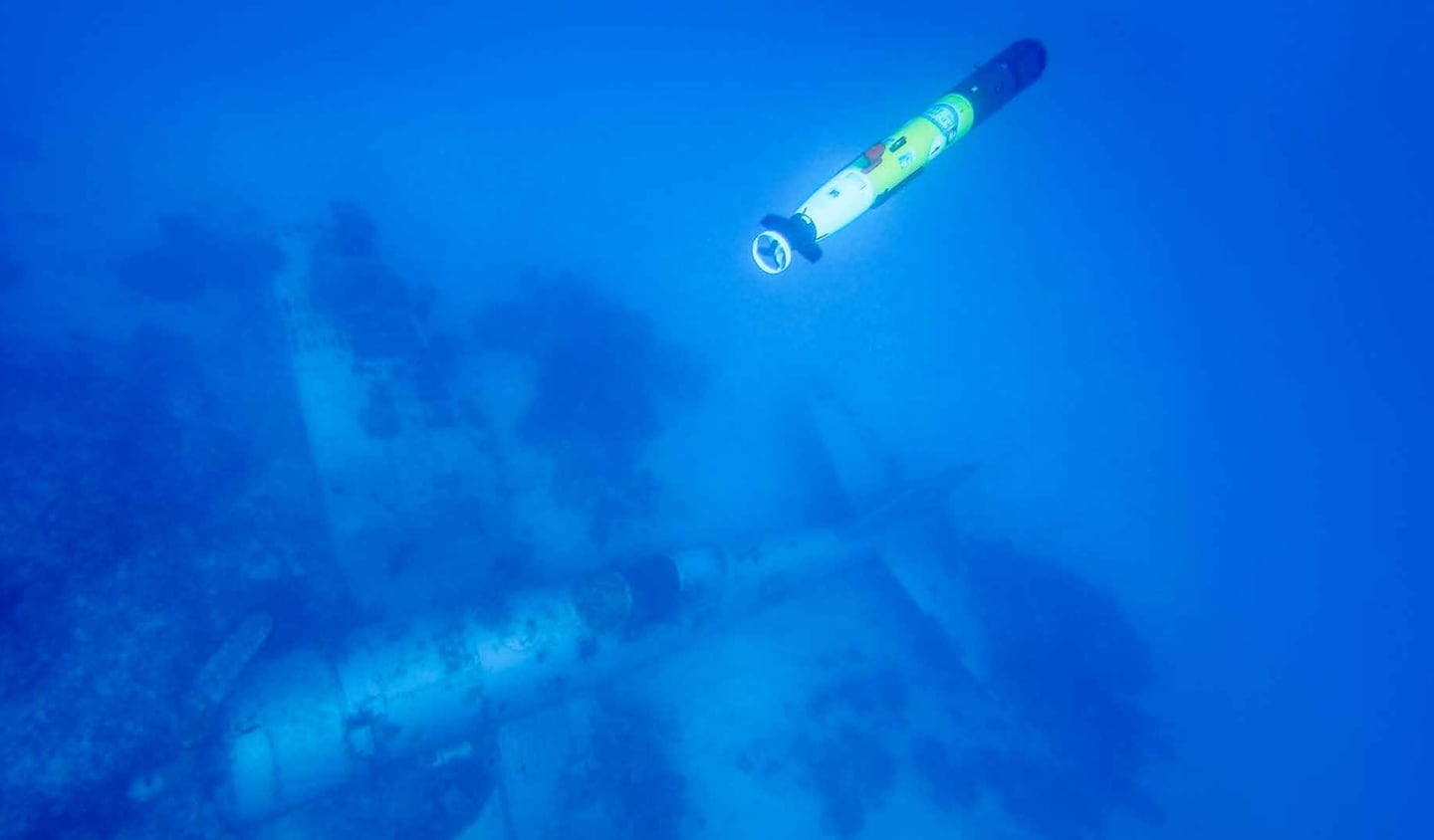 A REMUS Unmanned Underwater Vehicle (UUV) surveying a missing Corsair aircraft in the western lagoon of the Republic of Palau. The UUV is equipped with side scan sonar to allow for mapping of the seabed even in poor water visibility, with variants of the same robotic technology in use by the US Navy. Subsequent forensic analysis of the Corsair by Project Recover found the data plates of the aircraft. Research of historical war records determined the plane was based from VMF-122 and shot down Nov. 21, 1944; the pilot safely escaped, swam outside the lagoon, and was recovered  by a rescue seaplane from his squadron.