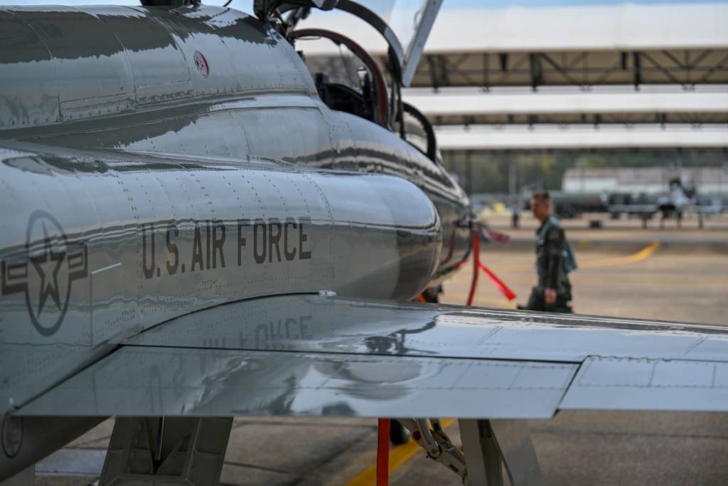 A graduate of the 49th Flying Training Squadron's Introduction to Fighter Fundamentals course walks in front of a T-38C Talon Nov. 11, 2020, on Columbus Air Force Base, Miss. The T-38 is a two-seat trainer jet used by student pilots selected for the fighter track in pilot training. (Airman 1st Class Davis Donaldson/Air Force)