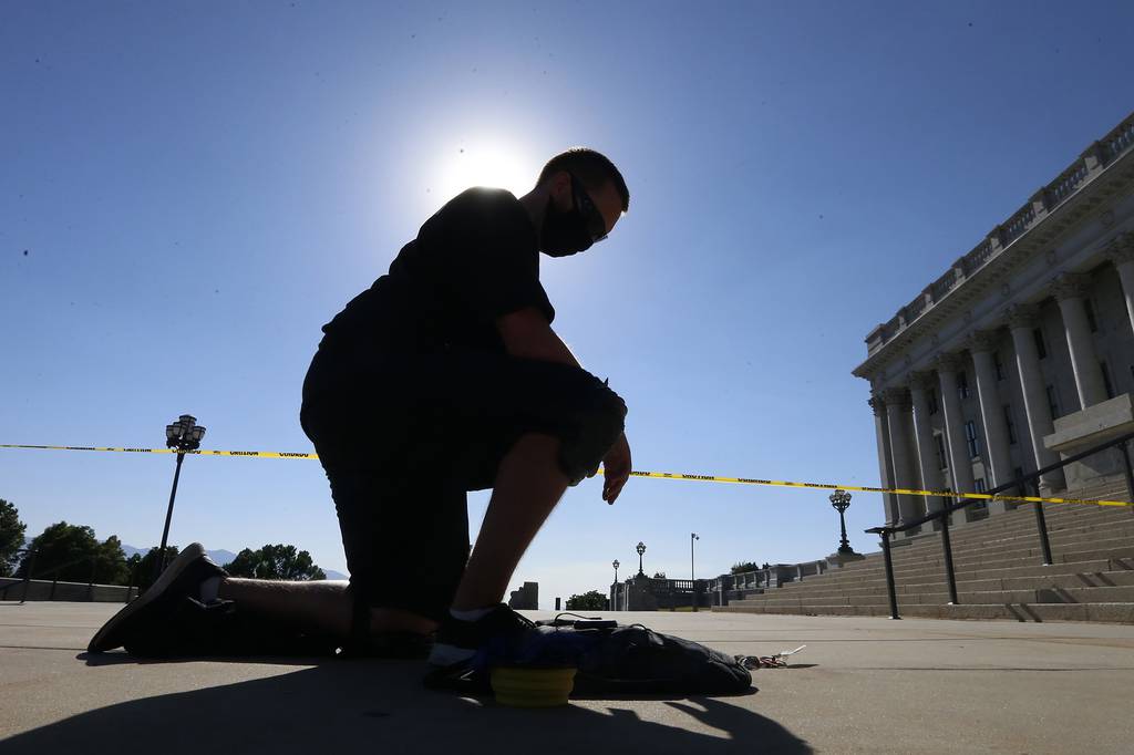 Shane Brooks, a Marine Corps veteran, kneels for nine hours outside the Utah Capitol to call attention to racial injustice, police brutality and mental health, Thursday, Aug. 6, 2020, in Salt Lake City.