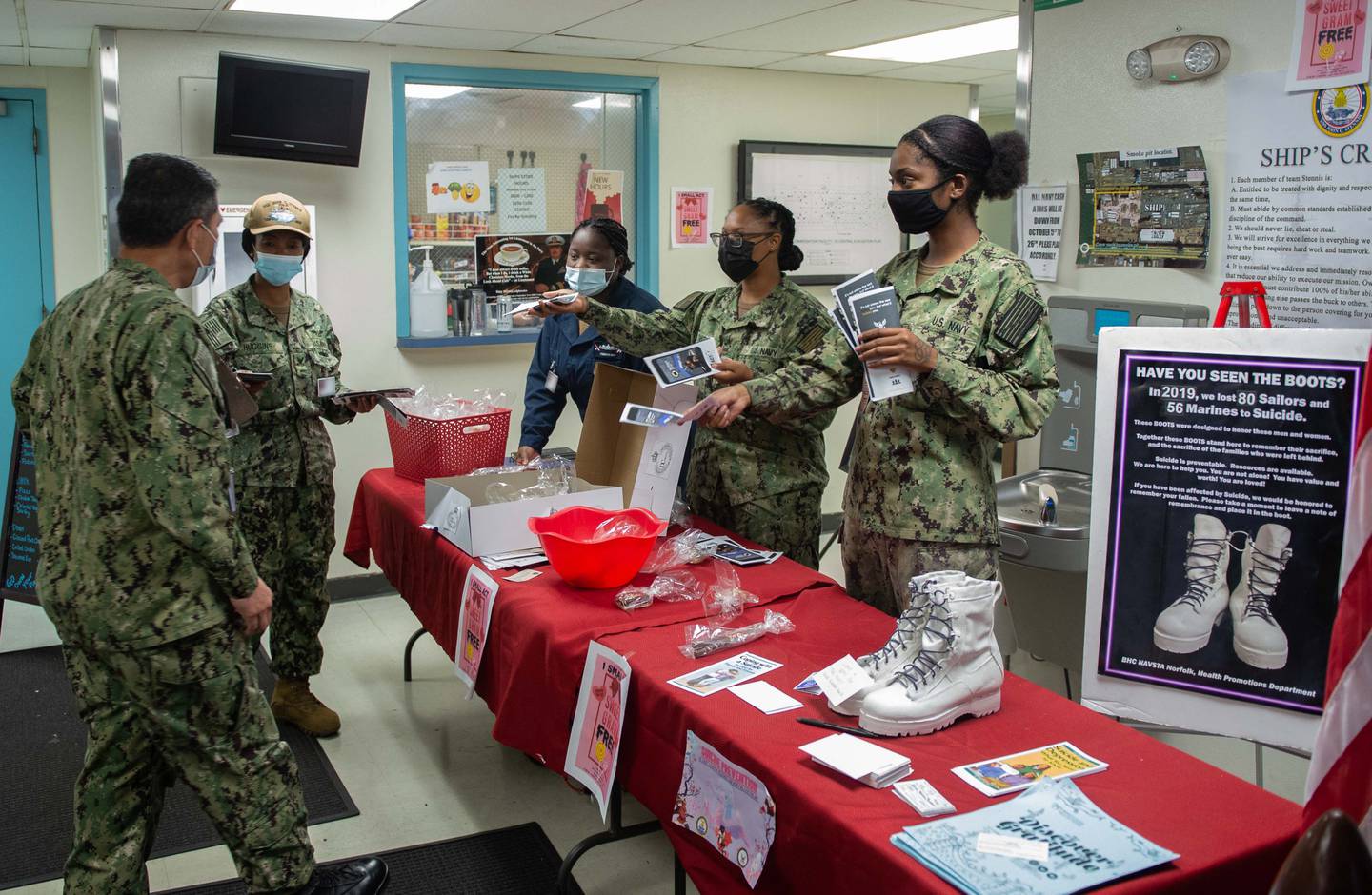Navy sailors assigned to the aircraft carrier John C. Stennis distribute pamphlets to raise awareness for suicide prevention in Newport News, Virginia, Sep. 30, 2021.