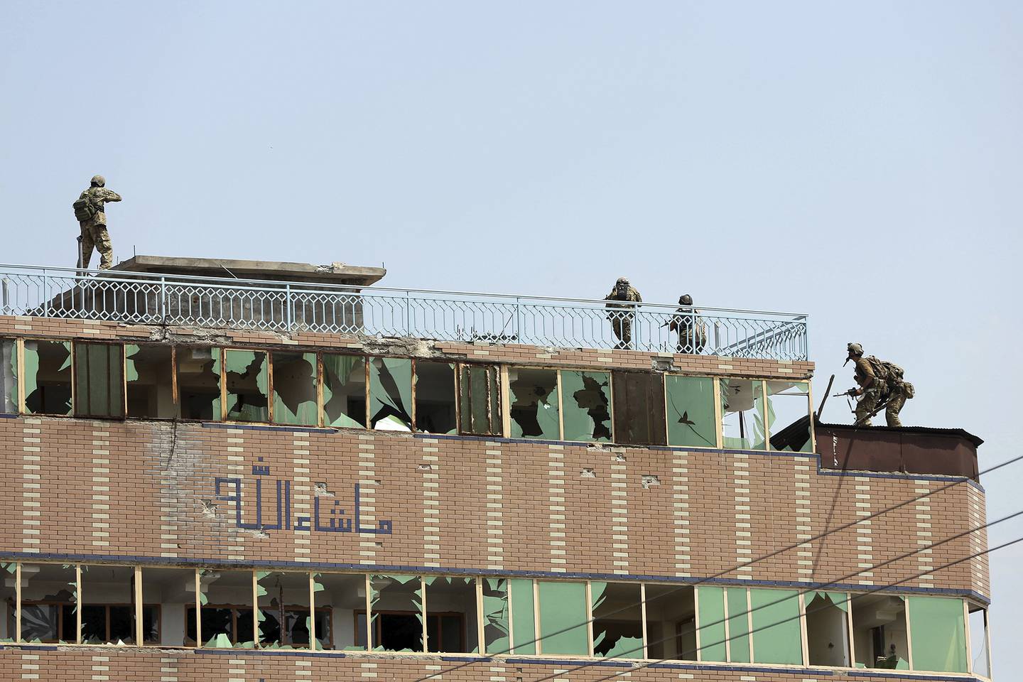 Afghan security personnel take position on the top of a building where insurgents were hiding, in the city of Jalalabad, east of Kabul, Afghanistan, Monday, Aug. 3, 2020.