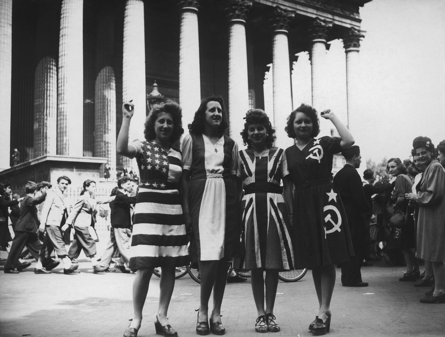 A group of women wearing dresses representing flags of the Allied powers (from left to right: the U.S., France, Britain and the Soviet Union) outside the Eglise de la Madeleine on V-E Day in Paris, May 8, 1945.