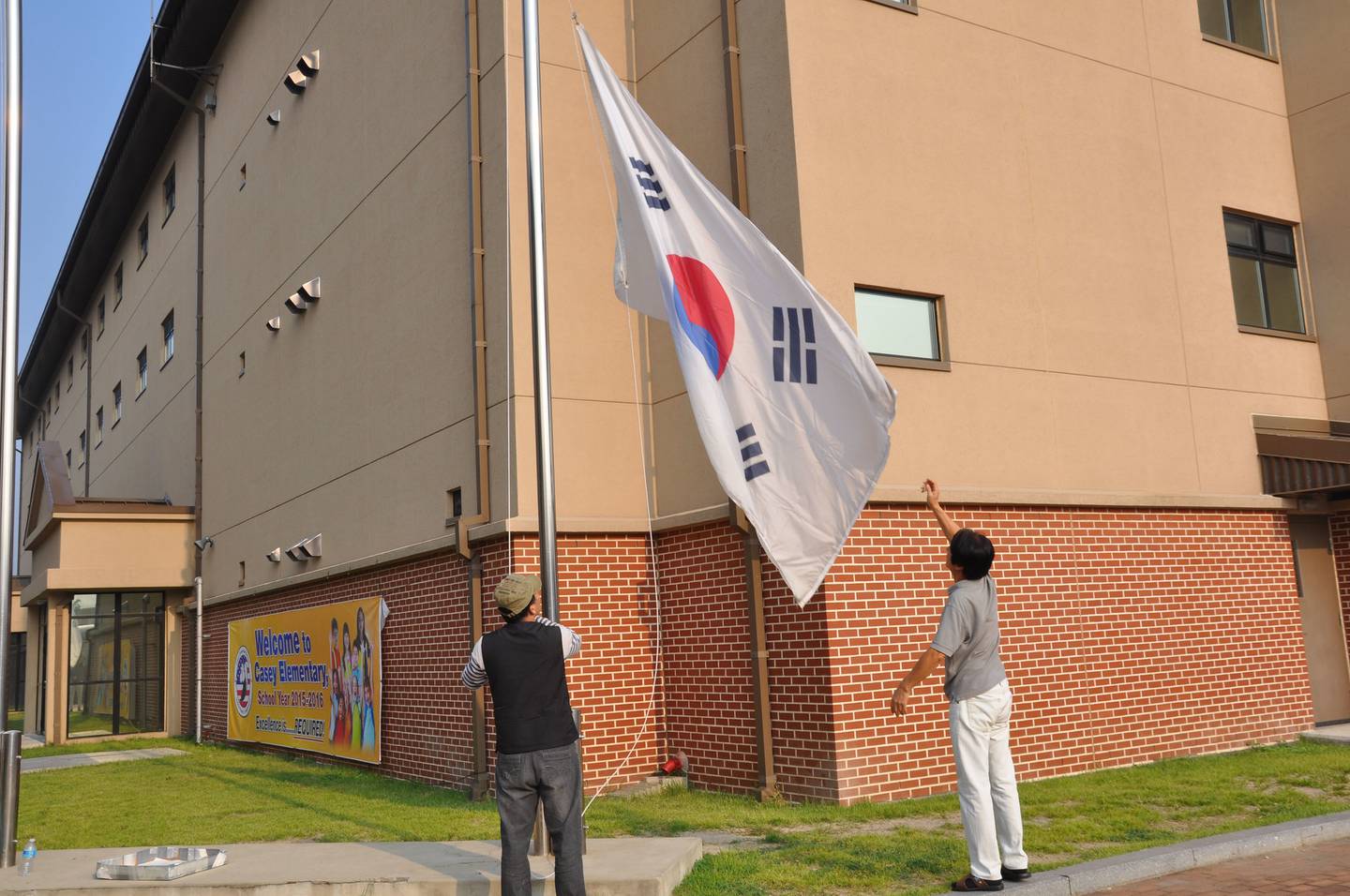 Korean veterans, who are also school employees, raise the flag on the first day of the 2015-16 school year at Casey Elementary School in South Korea.