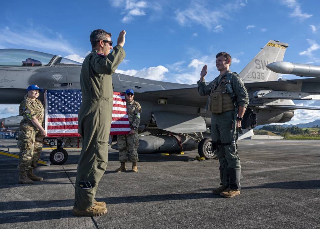 U.S. Air Force Maj. Joseph Butters administers the oath of office to U.S. Air Force Capt. Devin Mulvanny at a promotion ceremony during Exercise Relampago VI at Comando Aereo de Combate Number 5 in Rionegro, Colombia, on July 19, 2021. (Senior Airman Duncan Bevan/Air Force)