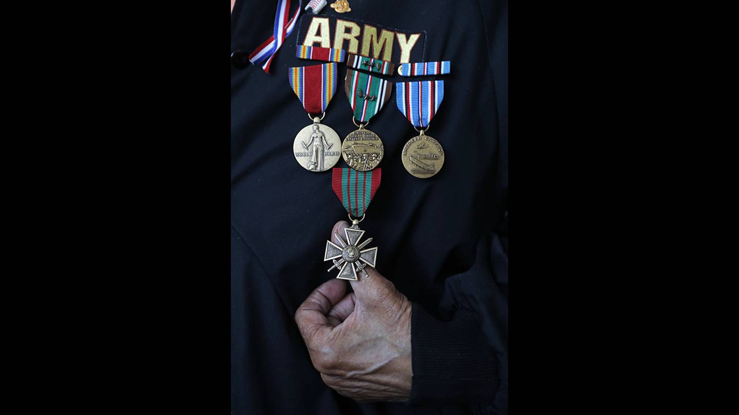 World War II veteran Johnnie Jones Sr. poses for a portrait holding his Croix Guerre Medal