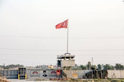 A Turkish military truck patrols next to a Turkish flag hoisted at the border with Syria on Aug. 14, 2019, in Akcakale, in Sanliurfa, southeastern Turkey.