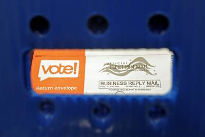 In this Aug. 5, 2020, file photo a vote-by-mail ballot is shown as viewed through the handle of a sorting tray at the King County Elections headquarters in Renton, Wash.