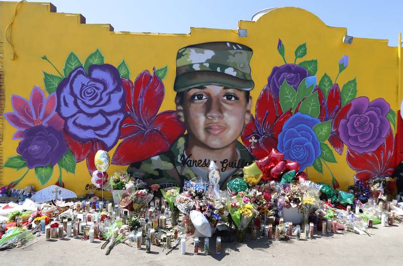 Offerings sit in front of a mural of slain Army Spc. Vanessa Guillen painted on a wall in the south side of Fort Worth, Texas, July 11, 2020.