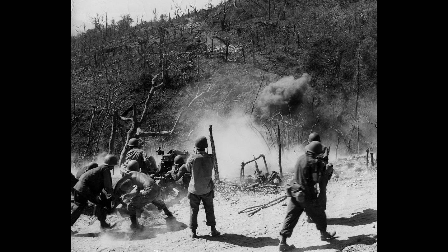 In this photo provided by the U.S. Army Signal Corps, this gun crew, part of a parachute artillery unit which dropped on the fortress island of Corregidor, is firing point-blank at a cave which the Japanese took over, March 3, 1945.