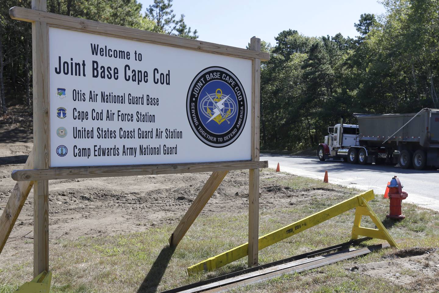 A truck drives past a welcome sign to Joint Base Cape Cod, Sept. 22, 2014, in Sandwich, Mass.