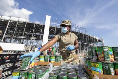 U.S. Army Spc. Ashley Jacobs, a combat medic with the Delaware Army National Guard Medical Detachment, organizes canned goods during a drive-thru food pantry on the grounds of Dover International Speedway in Dover, Del., June 24, 2020.