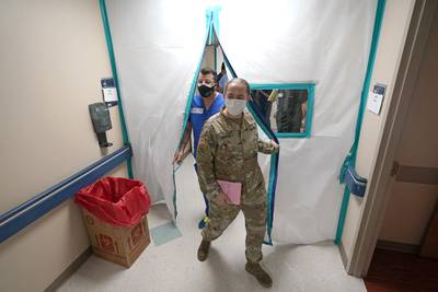 Urban Augmentation Medical Task Force members Army Maj. Katy Bessler, right, and Infectious Disease Physician Maj. Gadiel Alvarado enter a wing at United Memorial Medical Center, Thursday, July 16, 2020, in Houston.