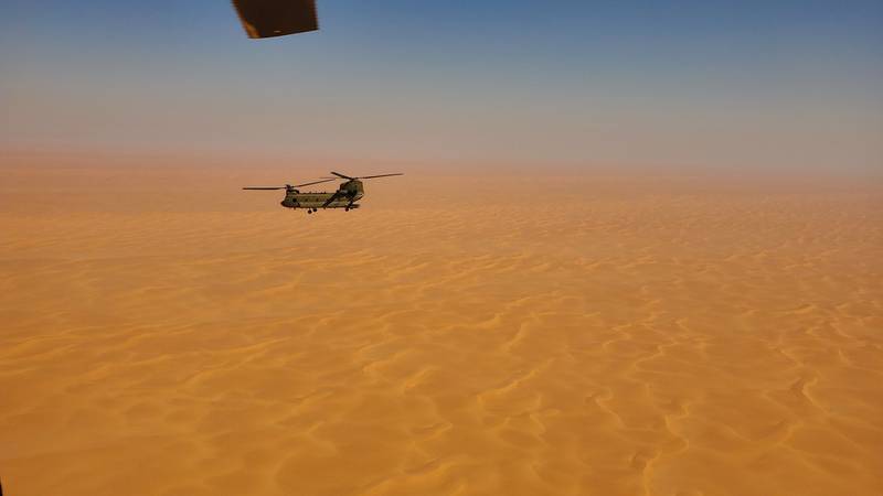 A CH-47 Chinook helicopter, operated by soldiers with Bravo Company, 3-238th General Support Aviation Battalion, 28th Expeditionary Combat Aviation Brigade, flies over a desert on Oct. 18, 2020, in the 28th ECAB's area of operations in the Middle East.