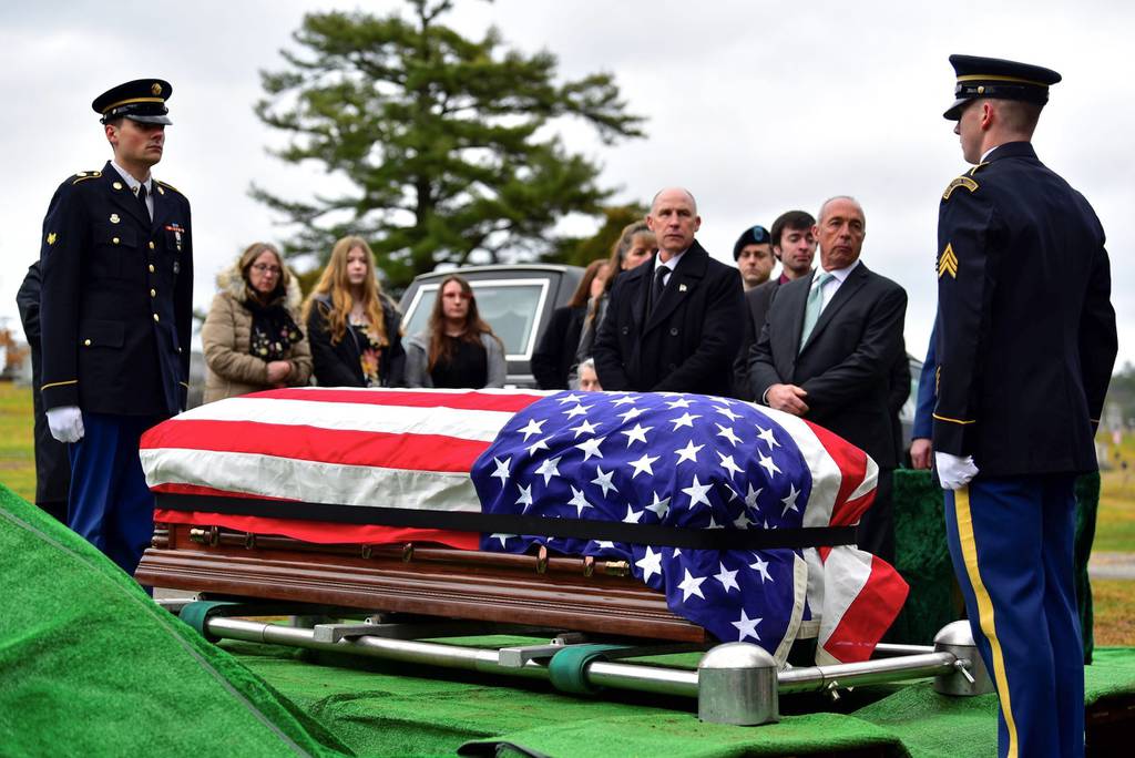 Family members surround the casket of Army Sgt. Alfred Sidney at his burial service in Littleton, N.H., on Thursday, Dec. 8, 2022.