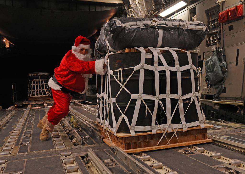 Santa Claus, portrayed by Tech. Sgt. Mike Morris, pushes a pallet of fuel onto a C-17 Globemaster III prior to a mission Dec. 23, 2011.
